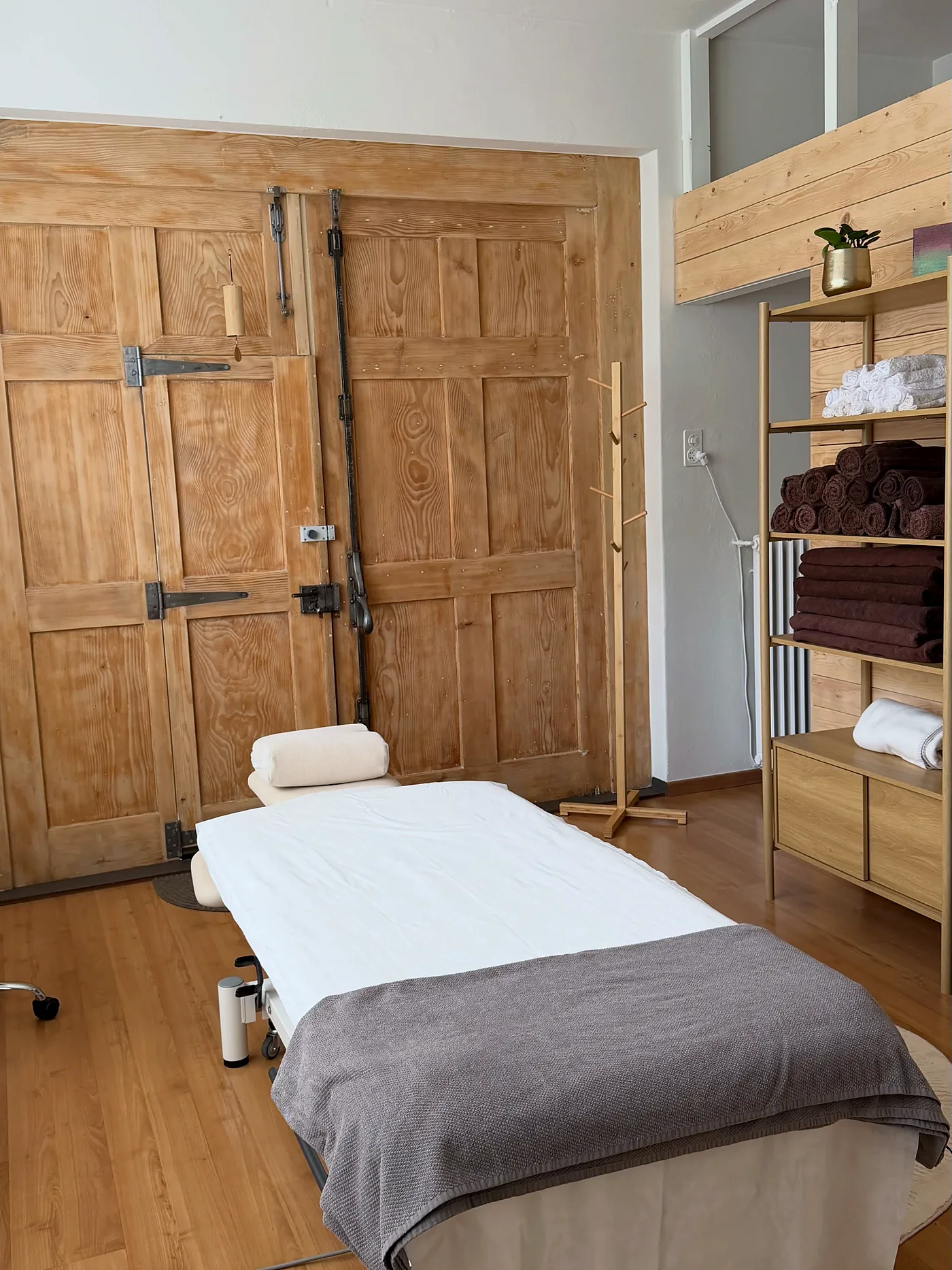 Behandlungsraum mit alter Holztür und Massageliege an der Luzernerstrasse 28 in Cham